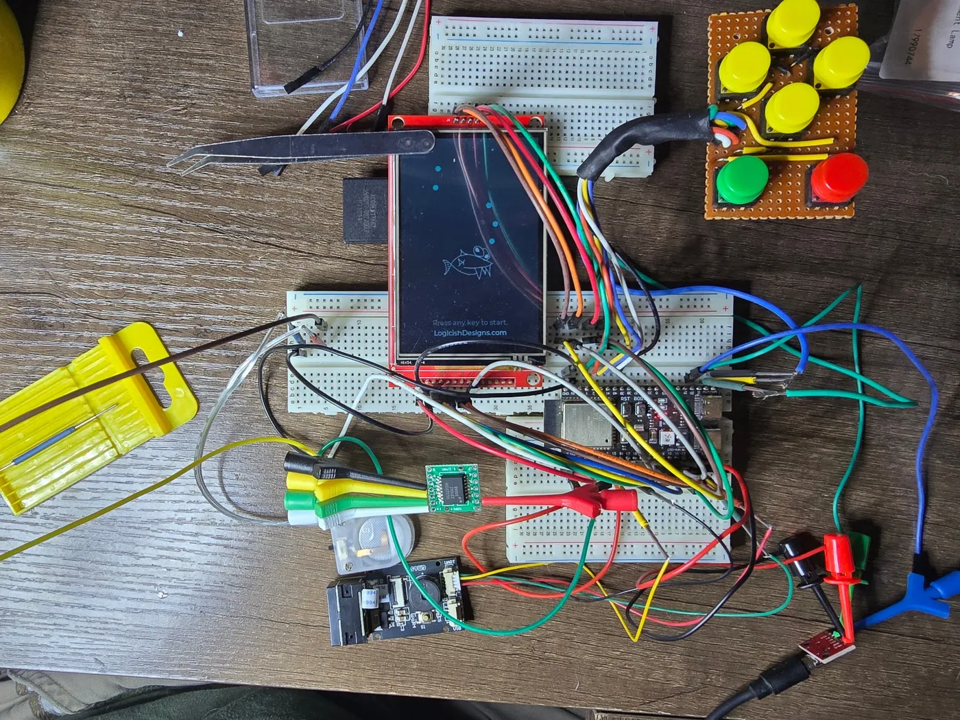 Full breadboard rig with the 3.5-inch display showing the fish splash screen, the six-button array, ESP32-S3, and the barcode scanner all wired in